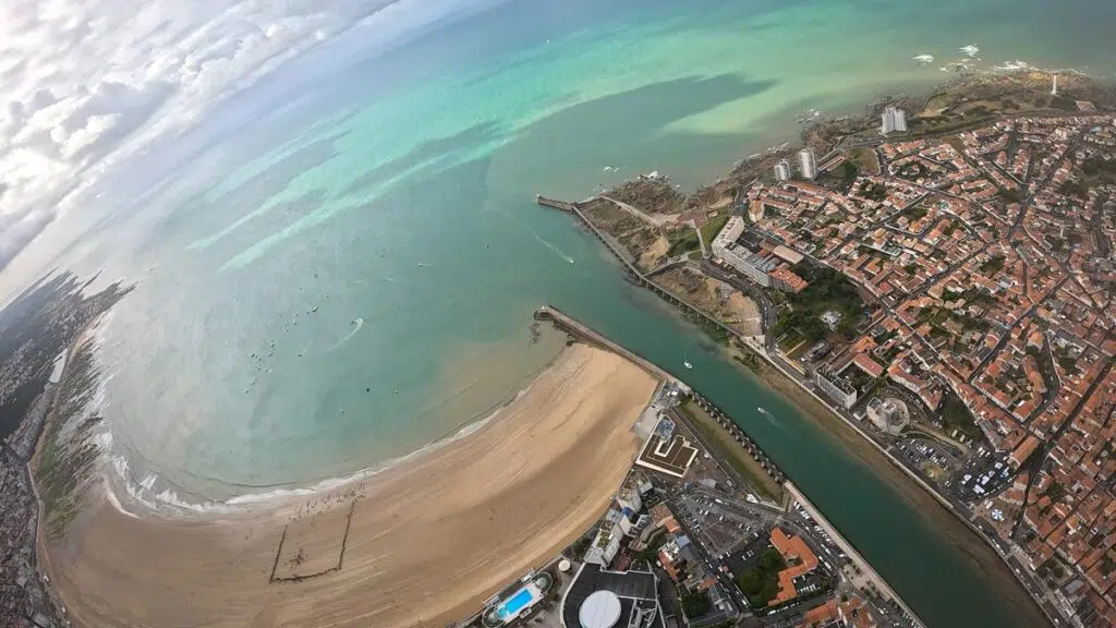Les Sables-d'Olonne vues depuis la voile : le port, l'arc de sable et l'Atlantique, photographiés en objectif grand angle lors d'un saut tandem.